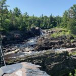 A footbridge crossing the rocky river gorge at Jay Cooke State Park, Minnesota, with people walking across to the far side